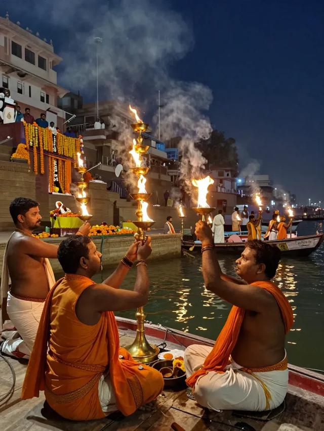 Priests raising brass Aarti lamps on the ghats at night